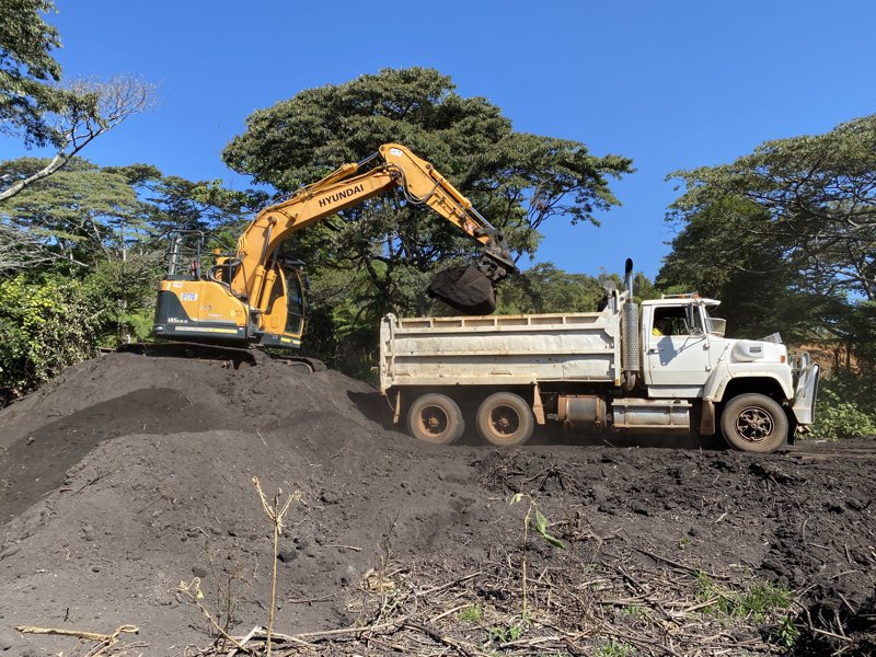 Excavator loading humate into a truck