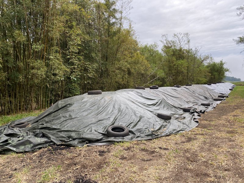 A covered stockpile of The Black Stuff under tarpaulin